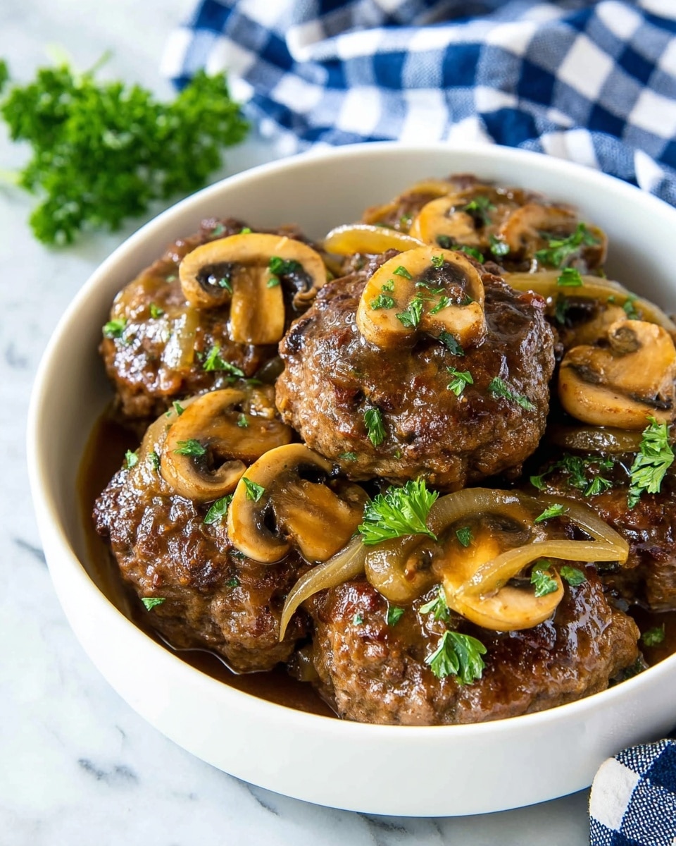 A close-up view of a white bowl filled with several thick, browned meat patties covered in a shiny brown gravy. The patties are topped and scattered with sliced cooked mushrooms that are light brown with darker edges. There are also thin slices of cooked onion mixed in and green parsley leaves placed on top and around the patties for garnish. The bowl sits on a white marbled surface with a blue and white checkered cloth in the background. photo taken with an iphone --ar 4:5 --v 7
