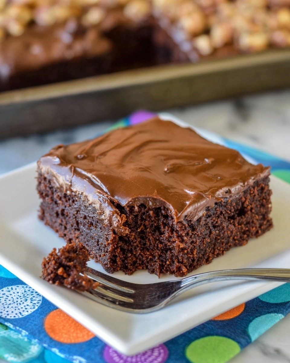 A thick square piece of chocolate brownie sits on a white square plate, showing two distinct layers: a dense, moist dark brown base with a rich and slightly crumbly texture, topped by a smooth, shiny, and firm lighter brown chocolate frosting with small cracks on the surface. A fork holds a bite-sized chunk of the brownie in front, highlighting the soft and gooey inside. The plate is placed on a colorful cloth with blue, green, orange, and purple circular patterns, and there is a blurred baking tray with scattered nuts in the background on a white marbled surface. photo taken with an iphone --ar 4:5 --v 7