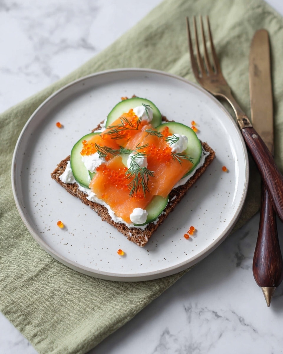A single slice of dark brown rye bread forms the base layer on a white plate. On top, there is a layer of smooth white cream cheese followed by neatly arranged thin slices of orange smoked salmon. Above the salmon, thin green cucumber slices are spaced evenly, topped with small dollops of creamy white sour cream or cream cheese. Bright orange fish roe is scattered over the top, along with small sprigs of green dill for garnish. The plate is set on a green cloth with a white marbled surface underneath. Photo taken with an iphone --ar 4:5 --v 7