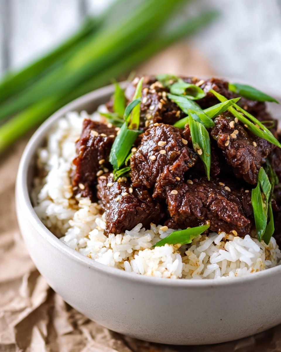 A white bowl filled with a base layer of fluffy white rice with small grains visible, topped with a layer of dark brown, glossy, chunky beef pieces that have a textured, tender look. The beef is garnished with bright green sliced scallions and sprinkled with small, light tan sesame seeds, all arranged neatly. The bowl sits on a crumpled brown paper, and the background shows a blurred white marbled texture and some green scallions. photo taken with an iphone --ar 4:5 --v 7