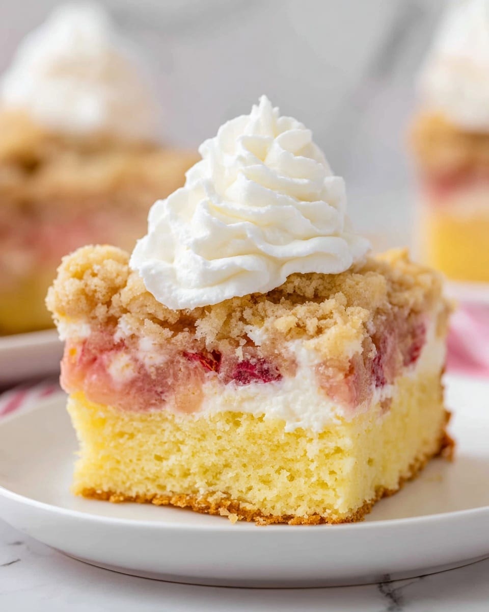 A close-up view of a white rectangular baking dish filled with a crumbly fruit crumble. The top layer is golden and uneven with small lumps and crumbly texture, showing bits of red fruit poking through beneath. The fruit layer underneath appears soft and juicy, visible in small patches, with red and yellow hues. The dish sits on a white marbled surface with a red and white striped cloth partially visible at the bottom of the image. photo taken with an iphone --ar 4:5 --v 7