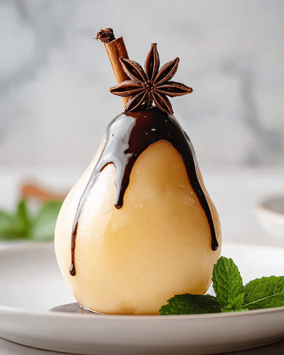 A single poached pear stands upright on a white plate, its soft creamy yellow skin smooth and slightly shiny. The pear is topped with a dark brown glossy chocolate sauce that drips artistically down one side, nearly reaching the plate. Above the pear’s stem sits a deep brown star anise and a cinnamon stick, adding a rustic touch. Beside the pear on the plate, there is a small fresh green mint leaf for color contrast. The background features a soft, out-of-focus white marbled texture, enhancing the pear’s warm tones. Photo taken with an iphone --ar 4:5 --v 7