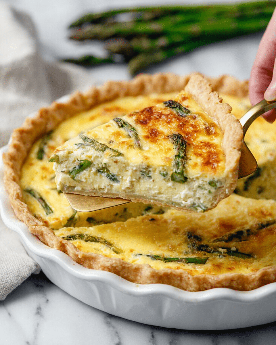 The image shows a close-up of a slice of quiche being lifted from a white ceramic pie dish by a woman's hand holding a golden spatula. The quiche has three visible layers: a thin, pale golden crust at the bottom with crimped edges, a thick creamy yellow egg filling with bits of green asparagus spread evenly throughout, and a top layer of melted cheese that is golden brown and slightly bubbly. The background features a white marbled surface with a few fresh asparagus spears visible in the upper part of the image. The photo taken with an iphone --ar 4:5 --v 7