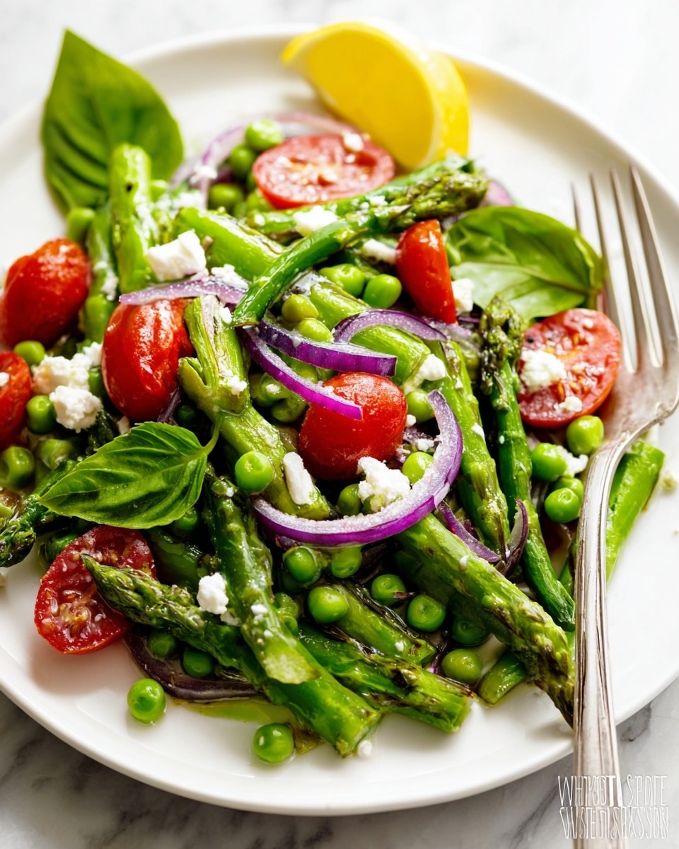A white plate holds a fresh vegetable salad with layers starting from a base of bright green asparagus cut into short pieces mixed with whole green peas. Scattered among these are halved red cherry tomatoes adding a pop of shiny red color. Thin strips of purple-red onion lie across the salad, providing contrast in texture and color. Small white crumbles of cheese are sprinkled evenly on top, creating a creamy texture contrast. Bright green basil leaves are placed on and around the salad for a fresh, leafy look. A wedge of bright yellow lemon sits at the back for a splash of color, and a silver fork rests on the side of the plate. The dish is set on a white marbled surface. photo taken with an iphone --ar 4:5 --v 7