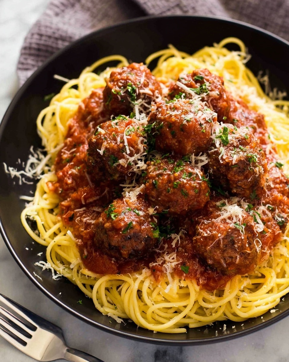A black bowl filled with one layer of twisted yellow spaghetti noodles at the bottom, topped with a thick, chunky layer of reddish-brown meat sauce with visible herbs, covering multiple brown meatballs arranged in a cluster. The meatballs are sprinkled with a light dusting of shredded pale yellow cheese and finely chopped green herbs. The bowl rests on a white marbled surface and next to it are two white forks with a woman’s hand holding one. Photo taken with an iphone --ar 4:5 --v 7