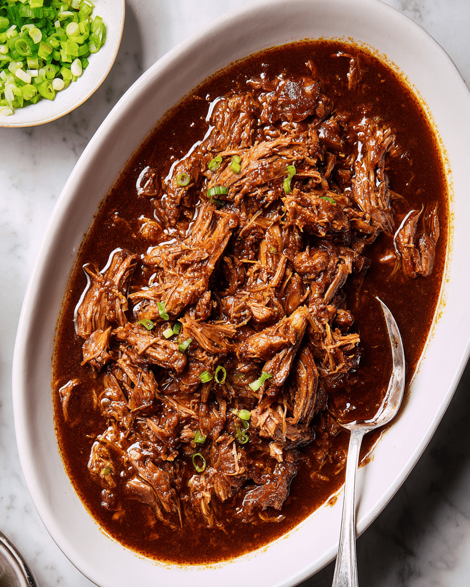 A white plate with a brown rim holds a serving of white rice as the bottom layer, topped with shredded beef covered in a dark brown sauce as the second layer. The beef is sprinkled with small sesame seeds and garnished with bright green chopped scallions and fresh cilantro leaves scattered on top and around. A silver fork rests partly on the edge of the plate, with a white marbled surface beneath the plate. Photo taken with an iphone --ar 4:5 --v 7