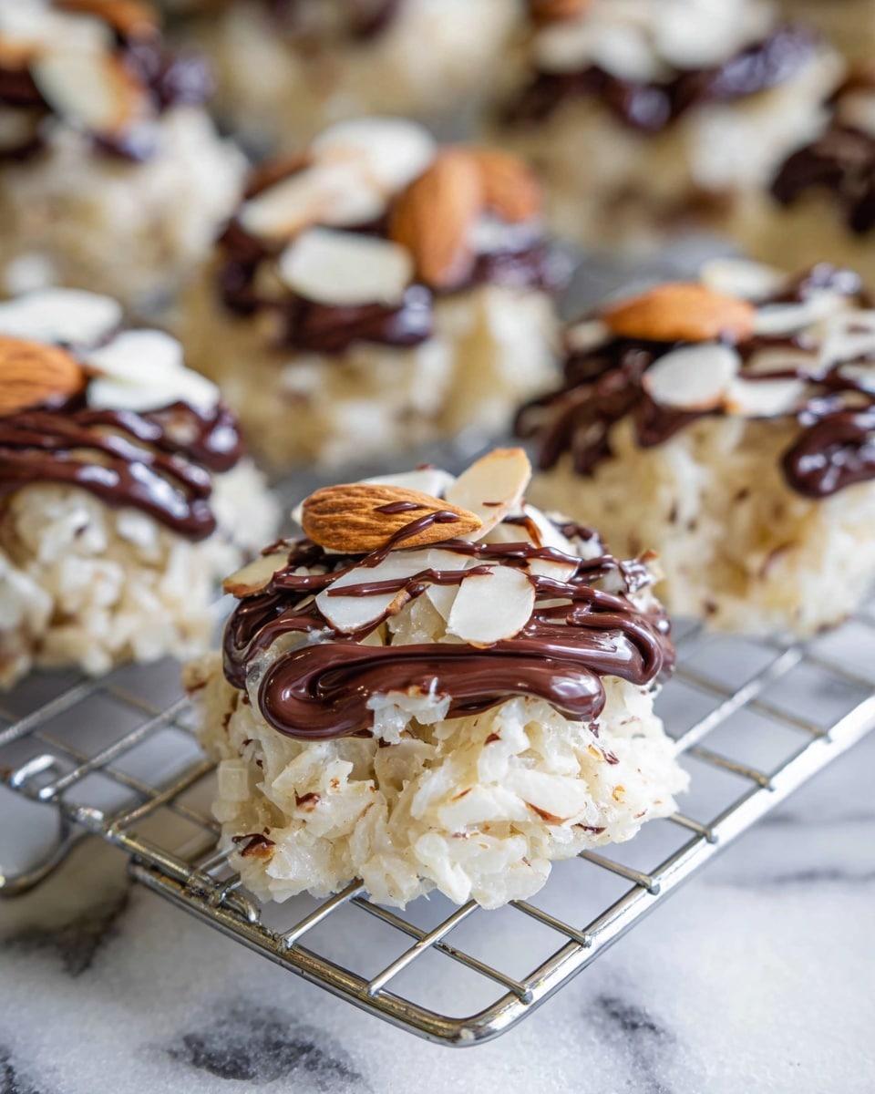 Small round treats sit on a silver wire rack above a white marbled surface. Each treat has a base layer of white rice-like flakes mixed with small brown bits giving it a rough texture. On top, a smooth dark brown chocolate drizzle swirls and runs down the sides. Thin almond slices are scattered over the chocolate drizzle, adding small beige and light brown accents. The treats are arranged in rows, with several shown in focus in the front and others blurred in the background. photo taken with an iphone --ar 4:5 --v 7