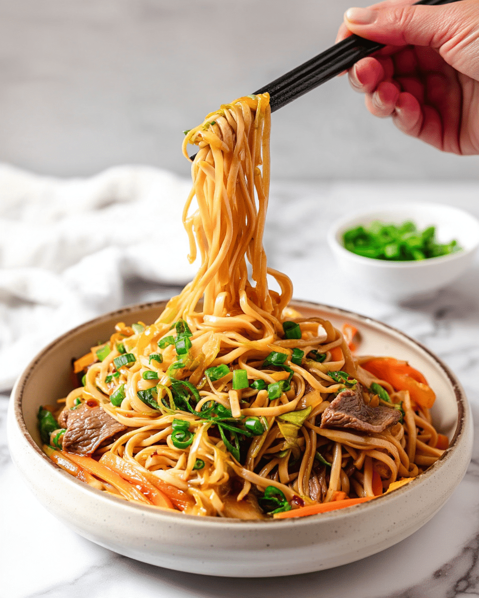 The image shows a white bowl filled with stir-fried noodles in a light brown sauce with visible layers of thin carrot sticks, light brown sliced mushrooms, and tender pieces of beef. The noodles are a pale golden color and are being lifted by dark chopsticks held by a woman's hand. The dish is garnished with bright green chopped spring onions scattered on top. In the background, there is a small white bowl filled with more chopped spring onions placed on a white marbled surface. The overall look is fresh and colorful with warm tones and a mix of textures. photo taken with an iphone --ar 4:5 --v 7