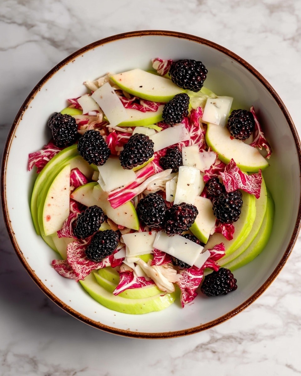 A close-up view of a salad in a white bowl with a thin brown rim on a white marbled surface, featuring three main layers: the bottom layer has thin slices of light green apples scattered around, the middle layer is mostly red and white radicchio leaves with their crinkled texture adding depth, and the top layer includes small blackberries and thin, irregular white cheese slices spread evenly, giving pops of dark and pale colors. photo taken with an iphone --ar 4:5 --v 7