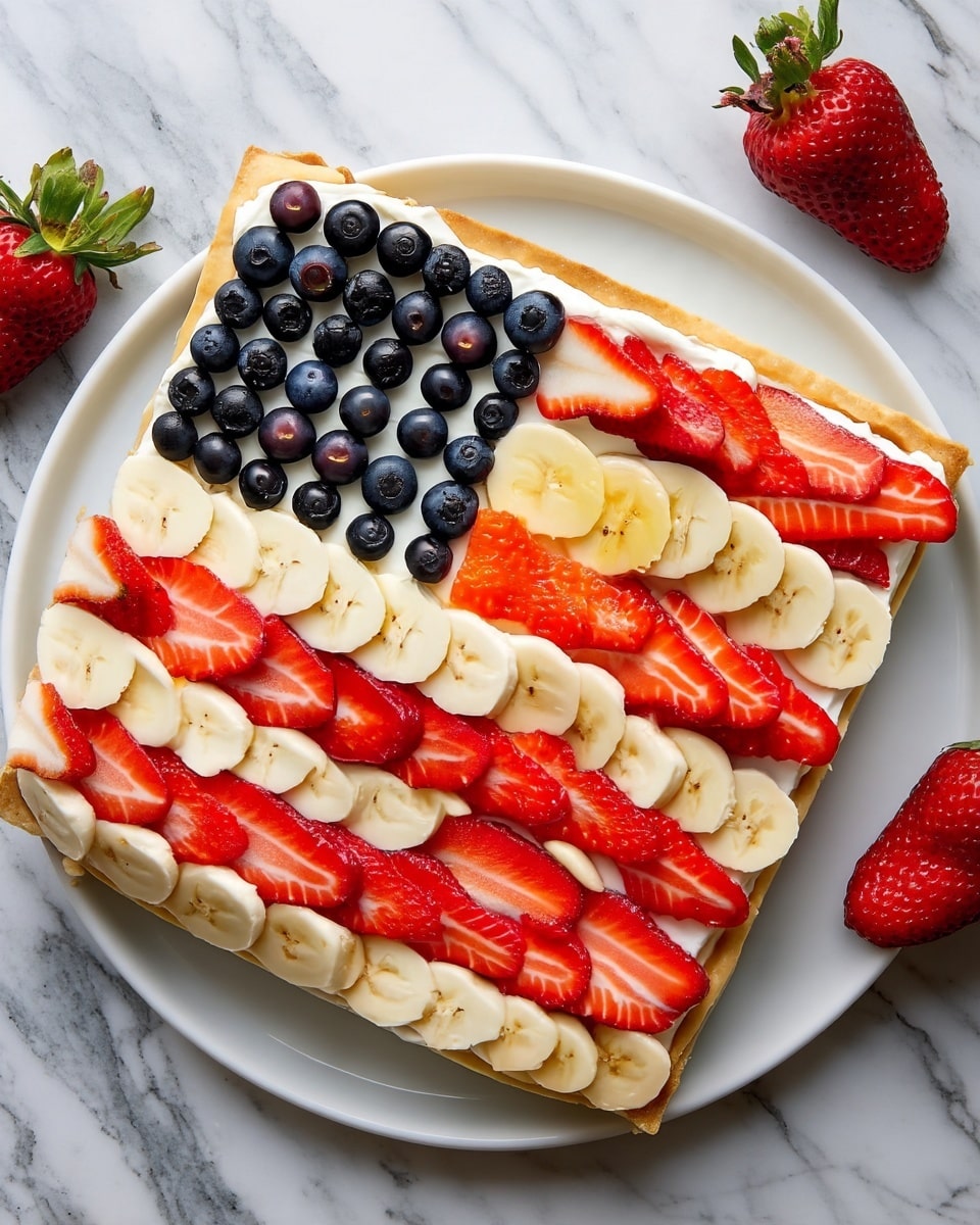 A rectangular tart sits on a white plate over a white marbled surface, styled like an American flag with neatly arranged fruit. The base layer is a golden-baked crust, topped with a smooth, creamy white layer that covers the whole tart. In the top left corner, a square panel of fresh dark blueberries forms the